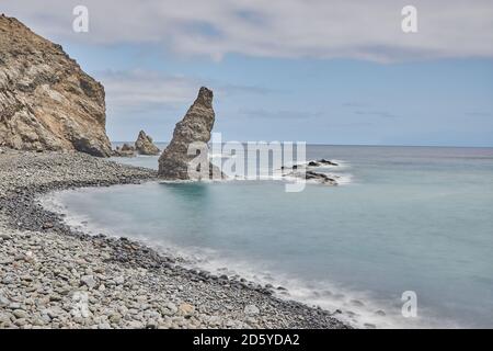 Long exposure at the coastline of la Gomera, Spain. Playa de la Caleta. Rock formation at a beach in La Gomera, Spain. Stock Photo
