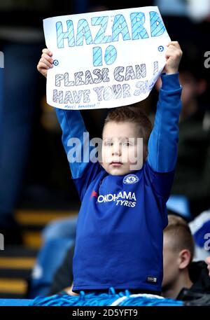 A young fan in the stands holds up a sign asking for Chelsea's Eden Hazard's shirt Stock Photo