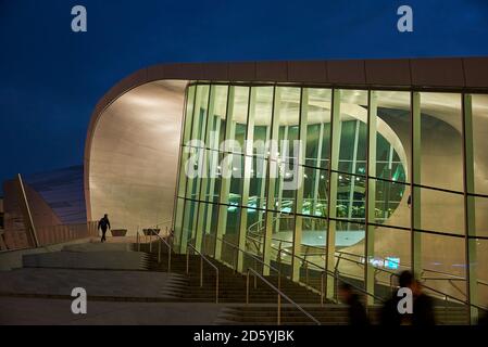 Netherlands, Arnheim, lighted glass facade of central station by night Stock Photo