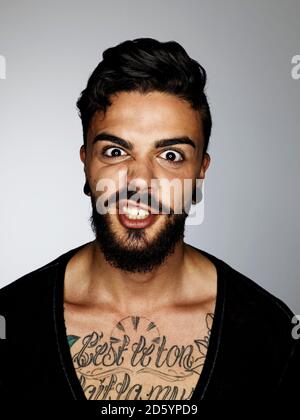Portrait of angry man with tatoo on his chest Stock Photo