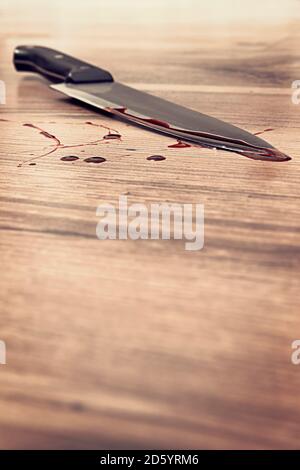 Blood stained knife on wooden floor Stock Photo