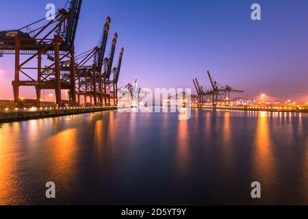 Germany, Hamburg, Port of Hamburg, Container Terminal Burchardkai in the evening Stock Photo