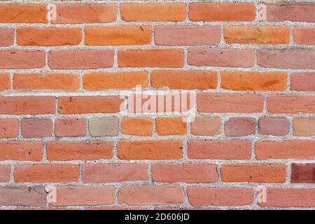 Antique red clay brick wall texture background with bricks in varying shades of orange and pink, and copy space Stock Photo