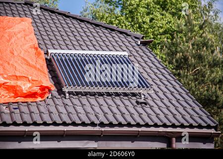 Vacuum pipe solar water heating system on the house roof. Stock Photo