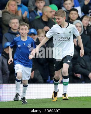 Football fans James and Daniel, who are raising money for Prostate Cancer UK and the British Heart Foundation running for their grandads, run around the pitch at half-time Stock Photo