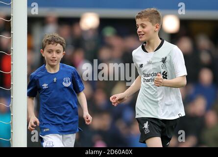 Football fans James and Daniel, who are raising money for Prostate Cancer UK and the British Heart Foundation running for their grandads, run around the pitch at half-time Stock Photo