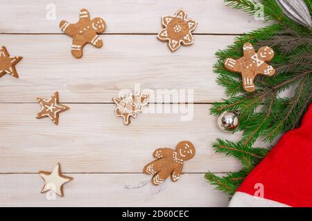 Two gift boxes with red ribbons on a light wooden background,ginger shaped cookies and Christmas tree branches. Concept of New Year and Christmas, gif Stock Photo