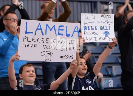 Tottenham Hotspur fans hold up signs asking for the player's shirts