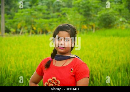 Close up of a Teenager girls wearing traditional Indian dress in an agricultural field with green paddy rice, selective focusing Stock Photo