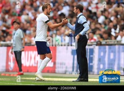 England's Harry Kane (left) and manager Gareth Southgate shake hands during the game Stock Photo