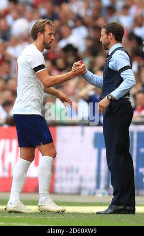 England's Harry Kane (left) and manager Gareth Southgate shake hands during the game Stock Photo