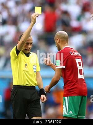 Referee Cuneyt Cakir shows a yellow card to Morocco's Karim El Ahmadi Stock Photo