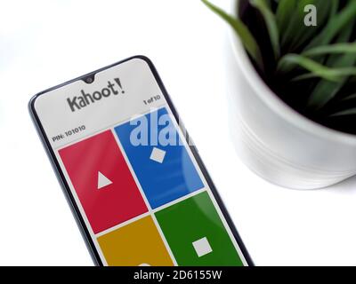 Lod, Israel - July 8, 2020: Modern minimalist office workspace with black mobile smartphone with Kahoot! app launch screen with logo on a white backgr Stock Photo