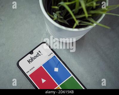 Lod, Israel - July 8, 2020: Modern minimalist office workspace with black mobile smartphone with Kahoot! app launch screen with logo on a marble backg Stock Photo