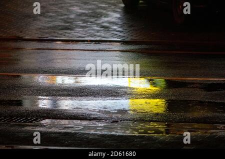 rain on asphlat at night. Rain drops in a puddle. city Stock Photo