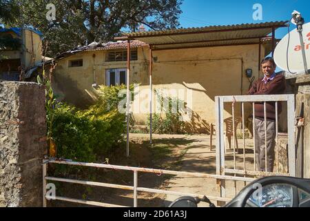 A man basking in the winter sun in his house at Mount Abu, Rajasthan, India Stock Photo