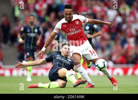 Arsenal's Pierre-Emerick Aubameyang (right) and Manchester City's John Stones battle for the ball Stock Photo