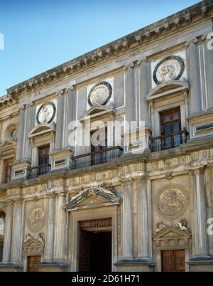 Spain, Andalusia, Granada. Charles V Palace. Its construction was ordered by the emperor Charles V due to the need for a place that met all the comforts of the time for the emperor and his family. The architect Pedro Machuca (c.1490-1550) began the works in 1527. Juan de Herrera designed the main cover on this facade, modifying Machuca's plan, with three linteled openings in the lower body, smaller on the sides than the central one, and another three of the same size in the upper body framed between Doric columns and with medallions with reliefs above them. Architectural detail of the western Stock Photo