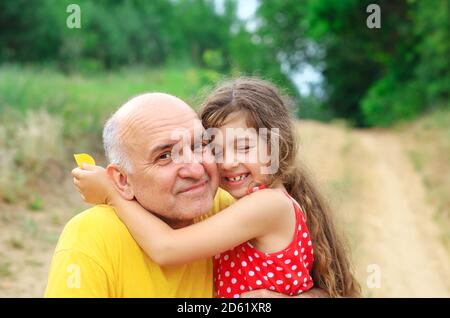 Portrait of granddad and granddaughter smiling at the park Stock Photo