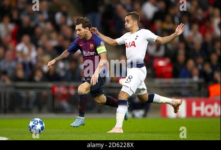 Barcelona's Lionel Messi (left) and Tottenham Hotspur's Harry Winks battle for the ball Stock Photo