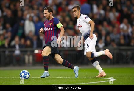 Barcelona's Lionel Messi (left) and Tottenham Hotspur's Harry Winks battle for the ball Stock Photo