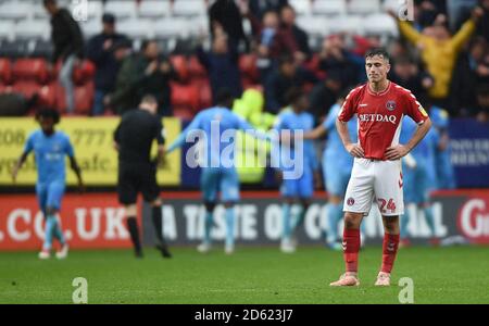 Charlton Athletic's Josh Cullen shows dejection as Coventry City players and fans celebrate their second goal Stock Photo