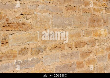 Antique golden brown color stone wall background with worn texture in full sunlight, with copy space Stock Photo