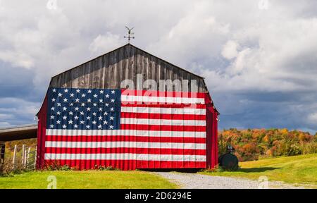 American flag painted on a farm barn during fall foliage season in New England Stock Photo
