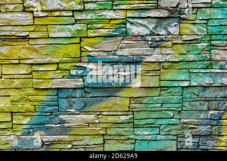 Colorful brick wall pattern in yellow, green and blue stones Stock Photo