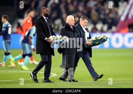 Ledley King, Tony Cottee and David Gold bring flower wreaths onto the pitch in memory of the Leciester City helicopter disaster victims prior to the Carabao Cup Fourth Round match