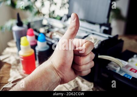 Refilling printer cartridges with multi-colored ink. Background Stock Photo