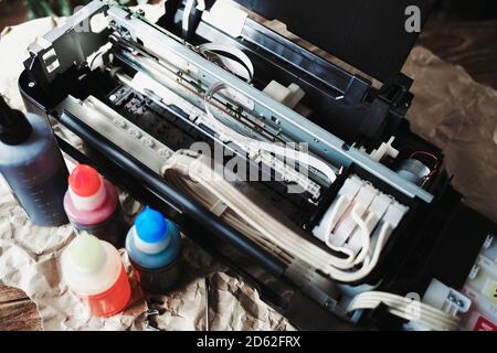 Refilling printer cartridges with multi-colored ink. Background Stock Photo