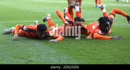 Luton Town's James Justin (left) celebrates scoring his side's third goal of the game with Harry Cornick (centre) and Pelly-Ruddock Mpanza (right)  Stock Photo