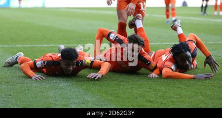 Luton Town's James Justin (left) celebrates scoring his side's third goal of the game with Harry Cornick (centre) and Pelly-Ruddock Mpanza (right)  Stock Photo