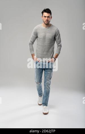 Handsome young man running or jumping in air on white background. Stock Photo