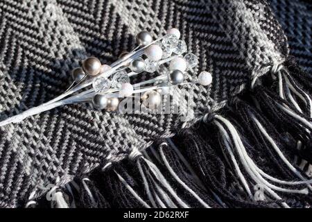 Full frame macro art texture background of a black and white knit scarf in a herringbone pattern, with a spray of glittery white holiday baubles Stock Photo