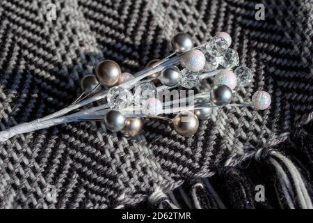 Full frame macro art texture background of a black and white knit scarf in a herringbone pattern, with a spray of glittery white holiday baubles Stock Photo