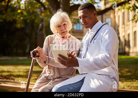 Young Afro-American doctor demonstrating a medical data on a tablet Stock Photo