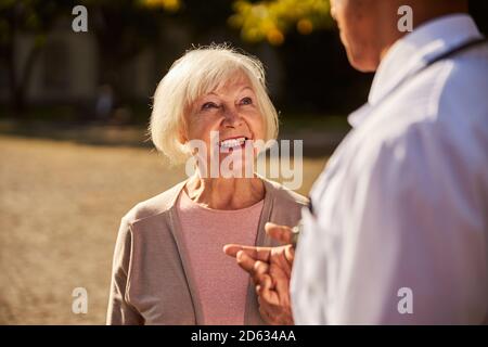 Pleased aging woman giving a smile to a doctor Stock Photo