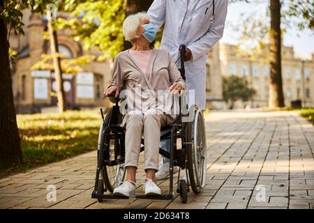 Content old lady telling something to her doctor Stock Photo