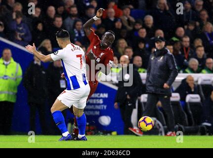 Liverpool's Sadio Mane goes down after the tackle by Brighton & Hove Albion's Beram Kayal Stock Photo