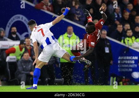 Liverpool's Sadio Mane goes down after the tackle by Brighton & Hove Albion's Beram Kayal Stock Photo