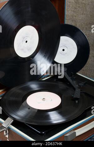 Old turntable. Several vinyl records are nearby. Retro party equipment. Stock Photo