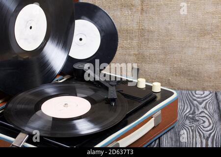 Old turntable. Several vinyl records are nearby. Retro party equipment. Stock Photo