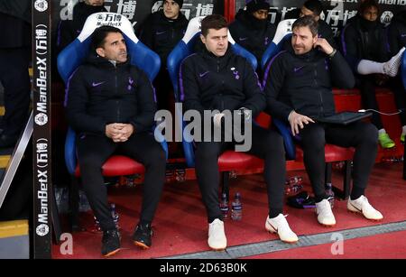 Tottenham Hotspur manager Mauricio Pochettino (centre), first team coach Jesus Perez (left) and Miguel D'Agostino in the dugout Stock Photo