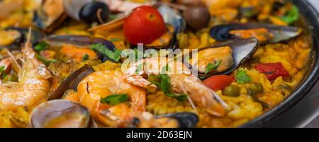 Spanish seafood Paella de Marisco, Paella Marinera with mussels, shellfish and scampis, panorama view Stock Photo