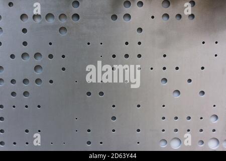 Metal surface with round different sizes holes for ventilation. Textured metal plate Stock Photo