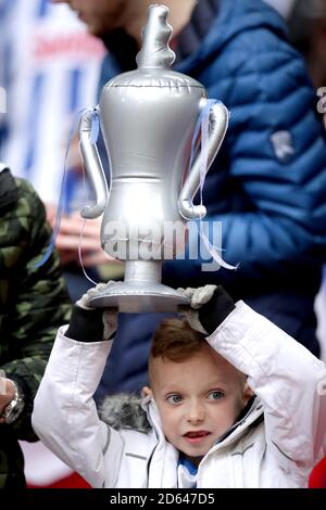 A general view of a young Brighton & Hove Albion fan holding up an inflatable replica of the FA Cup Trophy in the stands prior to the beginning of The FA Cup Semi Final Match at Wembley Stadium. Stock Photo