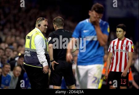 Referee Peter Bankes (centre left) speaks to a match day steward (left) after an incident involving Sunderland's Luke O'Nien (right) and Portsmouth fans during the game Stock Photo