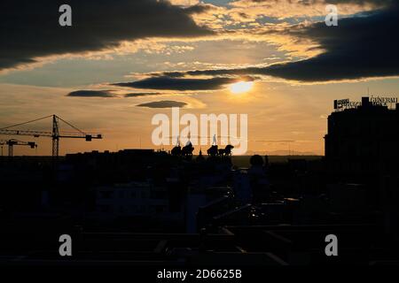 Golden sunset over the Madrid skyline with a crane and the silhouetted quadrigas of Calle de Alcalá 16, September 2020 Stock Photo